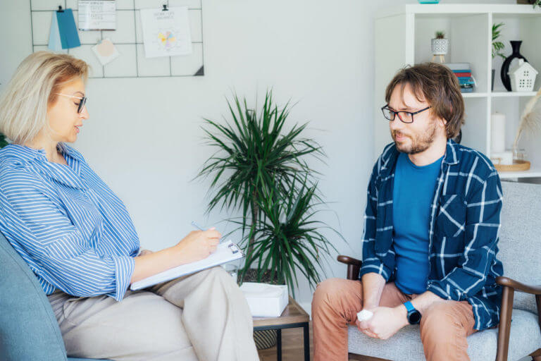 A female psychologist is having a session with an adult male patient.