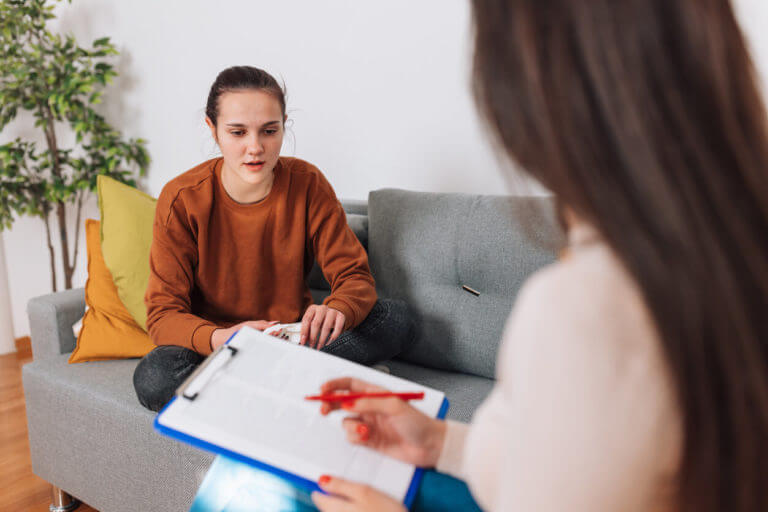 A female psychiatrist conducts a mental evaluation for ADHD on a teenage girl.